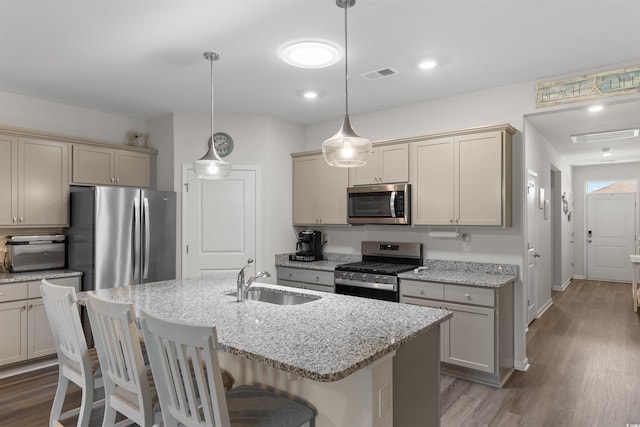 2438 Polaris Path, Myrtle Beach, SC 29577 - kitchen featuring appliances with stainless steel finishes, wood finished floors, a kitchen breakfast bar, and light stone counters