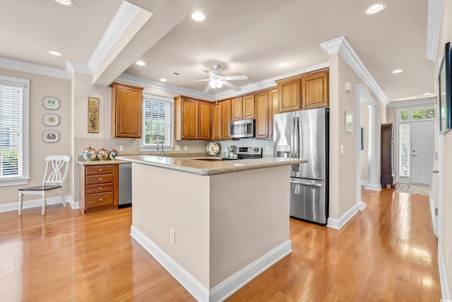 431 Huntington Lake Cir Unit 80, Pawleys Island, SC 29585 - kitchen featuring stainless steel appliances, crown molding, brown cabinets, light wood-type flooring, and a center island
