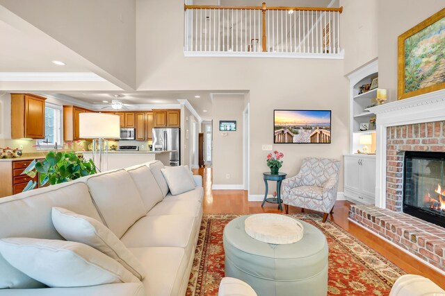 431 Huntington Lake Cir Unit 80, Pawleys Island, SC 29585 - living room with light wood-style flooring, a brick fireplace, a high ceiling, a ceiling fan, and built in features