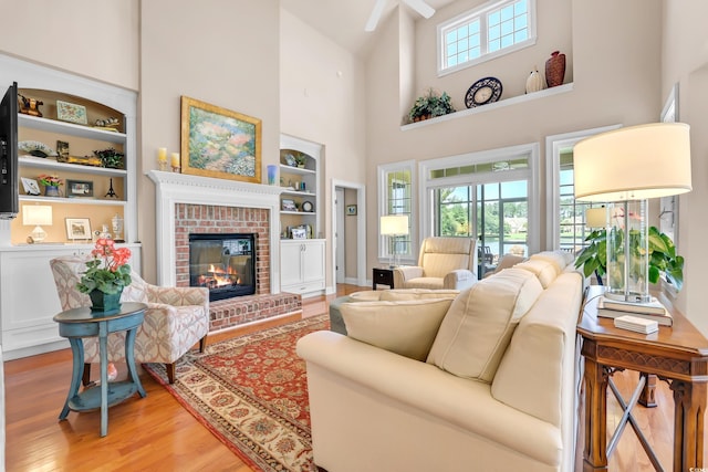 431 Huntington Lake Cir Unit 80, Pawleys Island, SC 29585 - living area with light wood-style floors, a towering ceiling, a fireplace, built in features, and a ceiling fan