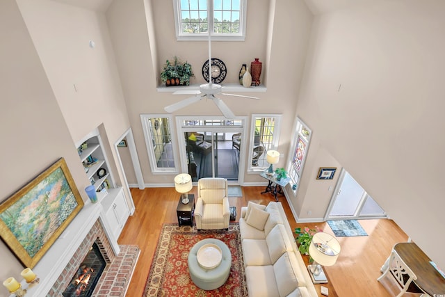 431 Huntington Lake Cir Unit 80, Pawleys Island, SC 29585 - living area with a towering ceiling, light wood-style floors, a fireplace, ceiling fan, and built in shelves