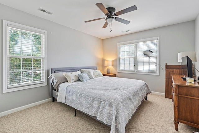 709 Triple Oak Ln, Garden City Beach, SC 29576 - bedroom featuring multiple windows, light carpet, and a ceiling fan