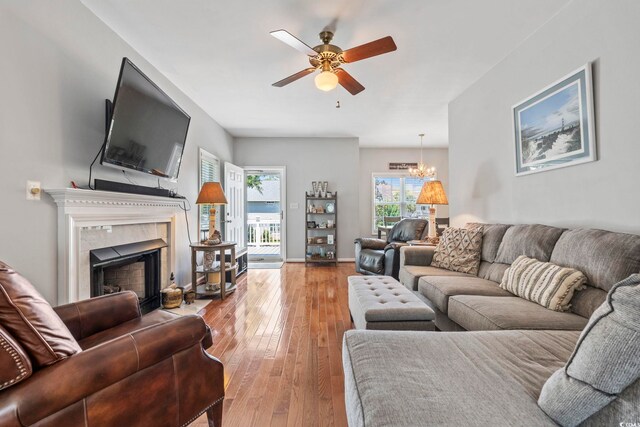 709 Triple Oak Ln, Garden City Beach, SC 29576 - living area featuring ceiling fan, wood-type flooring, a chandelier, and a tile fireplace