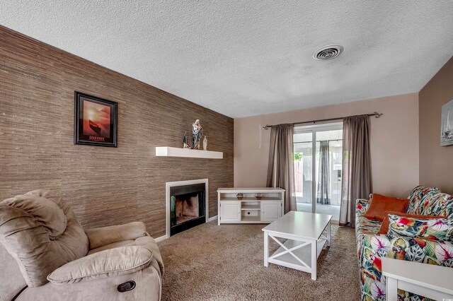 808 Myrtle Ct Unit 808, North Myrtle Beach, SC 29582 - carpeted living area featuring a textured ceiling, a fireplace, and an accent wall