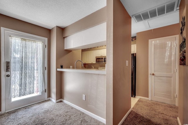 808 Myrtle Ct Unit 808, North Myrtle Beach, SC 29582 - kitchen with stainless steel microwave, light colored carpet, white cabinets, and light countertops