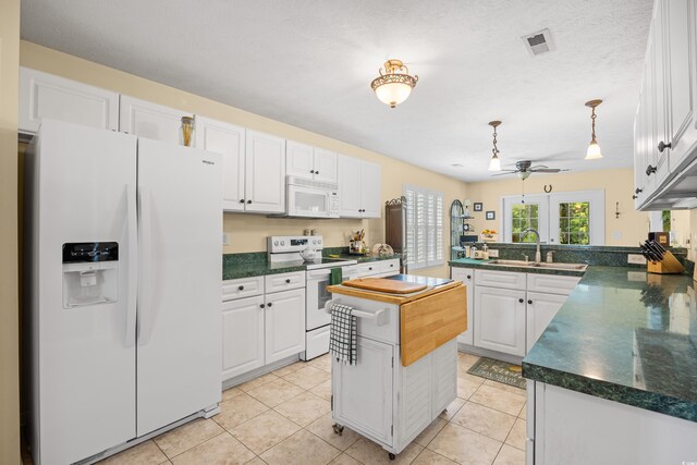 509 June Bug Ct, Myrtle Beach, SC 29588 - kitchen featuring white appliances, a peninsula, dark countertops, and white cabinetry