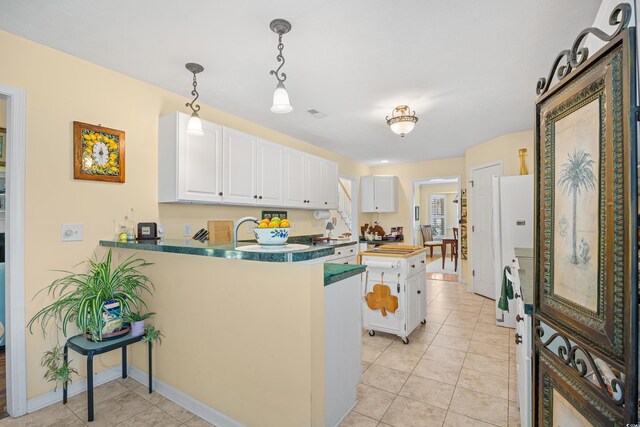 509 June Bug Ct, Myrtle Beach, SC 29588 - kitchen with white cabinets, a peninsula, pendant lighting, and light tile patterned floors
