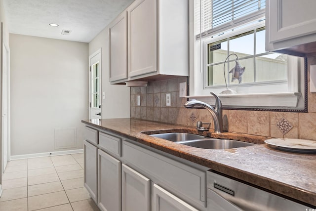 1007 Autumn Dr, Murrells Inlet, SC 29576 - kitchen featuring stainless steel dishwasher, decorative backsplash, light tile patterned flooring, and dark stone counters