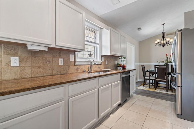 1007 Autumn Dr, Murrells Inlet, SC 29576 - kitchen featuring appliances with stainless steel finishes, light tile patterned floors, white cabinetry, a chandelier, and lofted ceiling