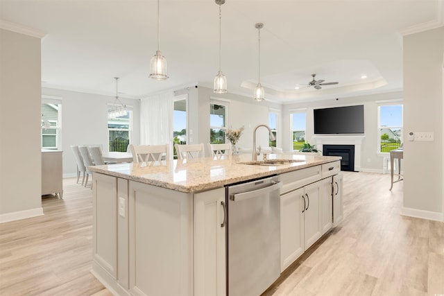 5087 Sundrop Ln, Little River, SC 29566 - kitchen with ornamental molding, stainless steel dishwasher, a center island with sink, a ceiling fan, and a glass covered fireplace