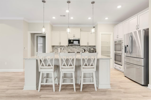 5087 Sundrop Ln, Little River, SC 29566 - kitchen featuring appliances with stainless steel finishes, decorative backsplash, a kitchen bar, light wood-style flooring, and ornamental molding