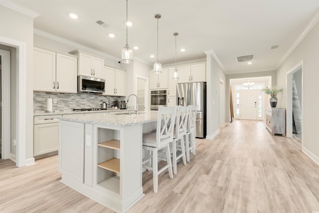 5087 Sundrop Ln, Little River, SC 29566 - kitchen with stainless steel appliances, decorative backsplash, a center island with sink, crown molding, and open shelves