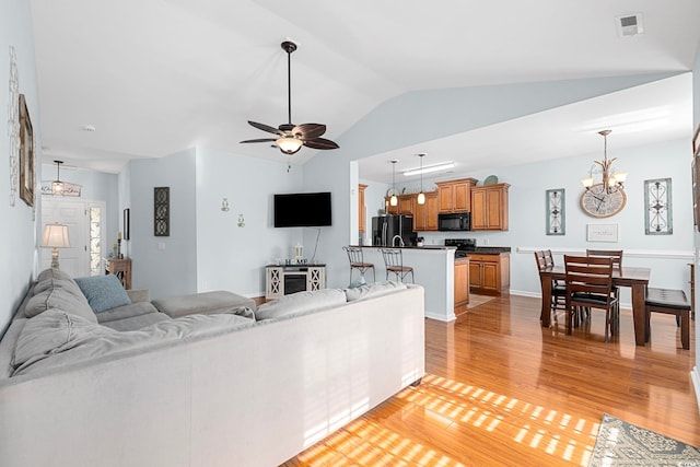 755 Wintercreeper Dr, Longs, SC 29568 - living area featuring light wood-type flooring, lofted ceiling, ceiling fan, and a chandelier