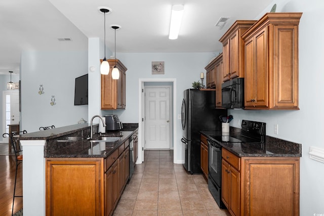 755 Wintercreeper Dr, Longs, SC 29568 - kitchen featuring black appliances, a peninsula, brown cabinets, and a breakfast bar area