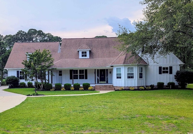 4719 National Dr, Myrtle Beach, SC 29579 - view of front of home with board and batten siding, covered porch, a front lawn, and roof with shingles