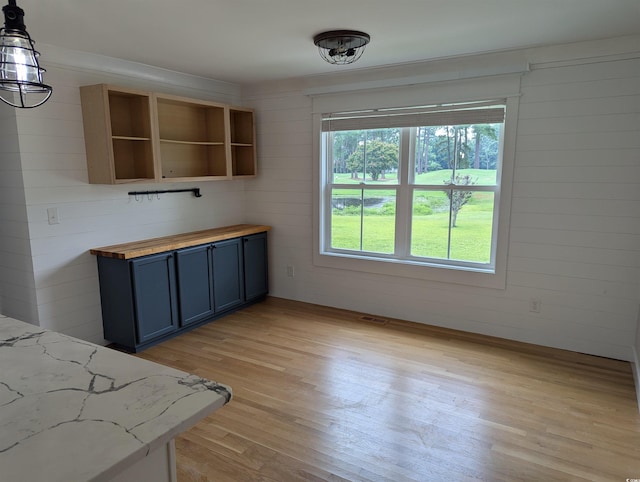 4719 National Dr, Myrtle Beach, SC 29579 - kitchen with butcher block countertops, healthy amount of natural light, light wood-type flooring, open shelves, and wooden walls
