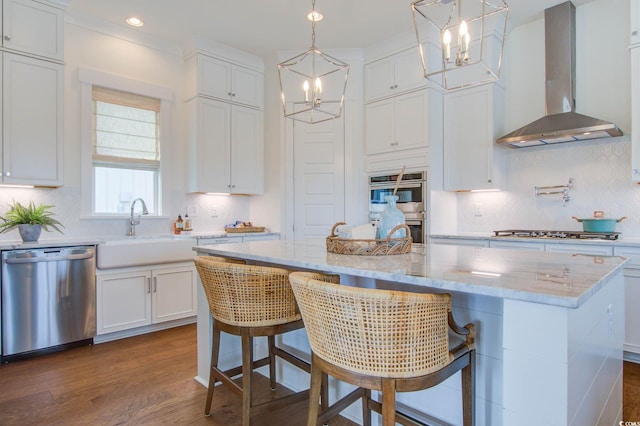 1627 Sayebrook Pkwy, Myrtle Beach, SC 29588 - kitchen with appliances with stainless steel finishes, wall chimney exhaust hood, a chandelier, white cabinets, and tasteful backsplash