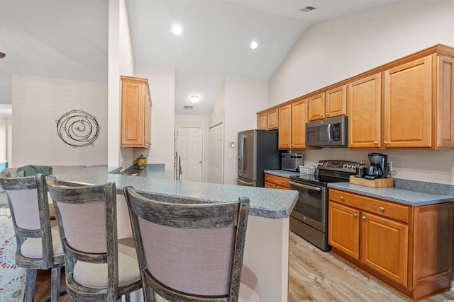 312 Caldera Ct, Murrells Inlet, SC 29576 - kitchen with appliances with stainless steel finishes, a breakfast bar area, light wood-type flooring, a peninsula, and high vaulted ceiling