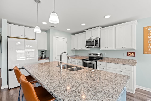 1108 Donald St, Conway, SC 29527 - kitchen with stainless steel appliances, white cabinetry, an island with sink, dark wood-style flooring, and a breakfast bar area