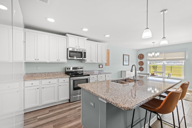 1108 Donald St, Conway, SC 29527 - kitchen with appliances with stainless steel finishes, light wood finished floors, a chandelier, white cabinets, and recessed lighting
