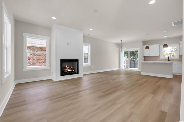 4329 Landing Rd, Little River, SC 29566 - unfurnished living room featuring a fireplace, recessed lighting, light wood-style floors, and a chandelier