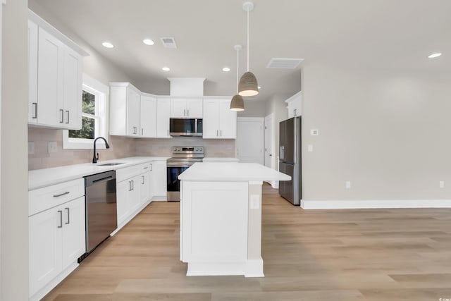 4329 Landing Rd, Little River, SC 29566 - kitchen with appliances with stainless steel finishes, a kitchen island, light countertops, tasteful backsplash, and light wood-style flooring