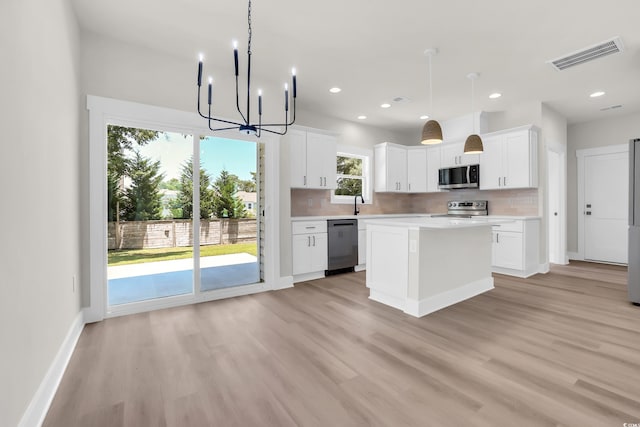 4329 Landing Rd, Little River, SC 29566 - kitchen with stainless steel appliances, light countertops, light wood-style floors, a chandelier, and tasteful backsplash