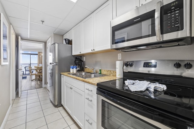 6900 N Ocean Blvd Unit 834, Myrtle Beach, SC 29572 - kitchen featuring stainless steel appliances, white cabinetry, light tile patterned floors, light countertops, and a paneled ceiling
