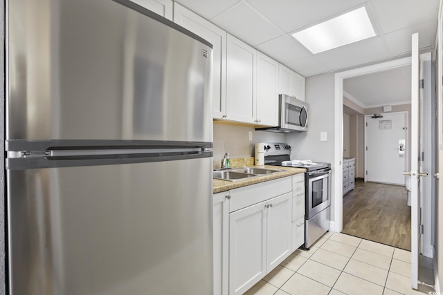 6900 N Ocean Blvd Unit 834, Myrtle Beach, SC 29572 - kitchen with stainless steel appliances, white cabinetry, light tile patterned floors, and light countertops