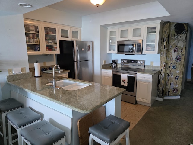 2100 Sea Mountain Hwy Unit 520, North Myrtle Beach, SC 29582 - kitchen with appliances with stainless steel finishes, a peninsula, a breakfast bar area, and white cabinets