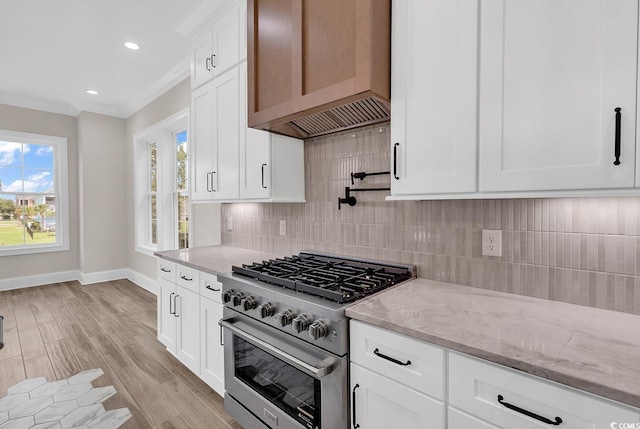1112 Whispering Winds Dr, Myrtle Beach, SC 29579 - kitchen featuring high end stainless steel range oven, tasteful backsplash, light stone counters, light wood-style floors, and white cabinetry