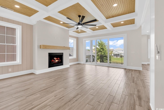 1112 Whispering Winds Dr, Myrtle Beach, SC 29579 - unfurnished living room with coffered ceiling, light wood-type flooring, beam ceiling, a warm lit fireplace, and crown molding
