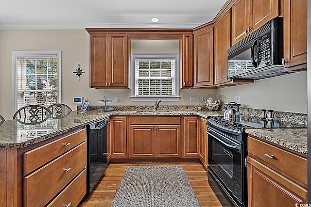 1011 Sable Palm Way, Surfside Beach, SC 29575 - kitchen with black appliances, a peninsula, brown cabinets, light wood finished floors, and crown molding