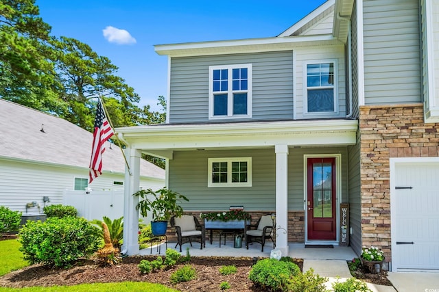 1007 Oak Marsh Ln, North Myrtle Beach, SC 29582 - back of house with a porch, stone siding, and a garage