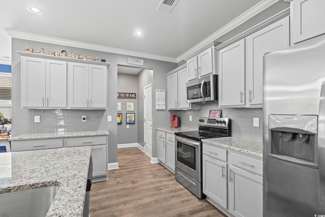 1007 Oak Marsh Ln, North Myrtle Beach, SC 29582 - kitchen with stainless steel appliances, recessed lighting, crown molding, tasteful backsplash, and light wood-style floors