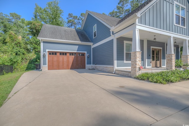 520 Oak Pond Ct, Conway, SC 29526 - view of side of home with board and batten siding, driveway, covered porch, an attached garage, and stone siding