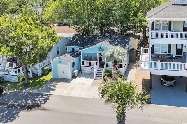 6001-Q21 S Kings Hwy, Myrtle Beach, SC 29575 - view of front of home featuring stairway, a porch, concrete driveway, and a shed