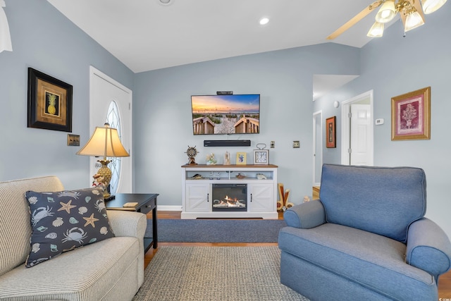 6001-Q21 S Kings Hwy, Myrtle Beach, SC 29575 - living room featuring vaulted ceiling, ceiling fan, a warm lit fireplace, and wood finished floors
