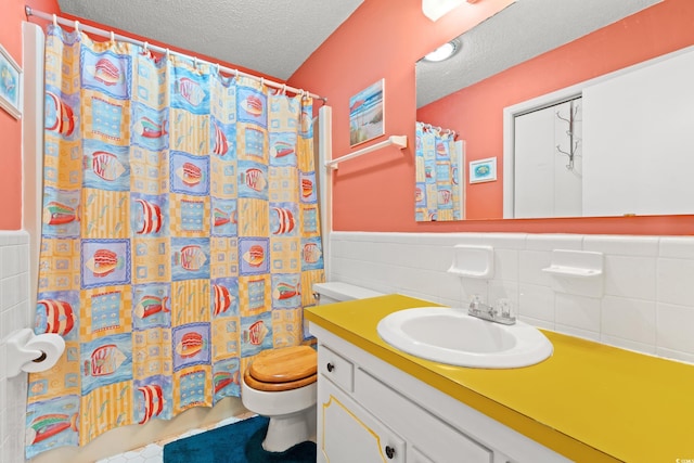 800 9th Ave S Unit N-1, North Myrtle Beach, SC 29582 - bathroom with a textured ceiling, vanity, a wainscoted wall, a shower with shower curtain, and tile walls