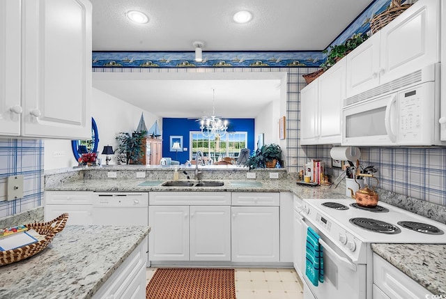4400 Turtle Ln Unit 2-D, Little River, SC 29566 - kitchen with white appliances, white cabinets, a chandelier, light stone countertops, and a textured ceiling