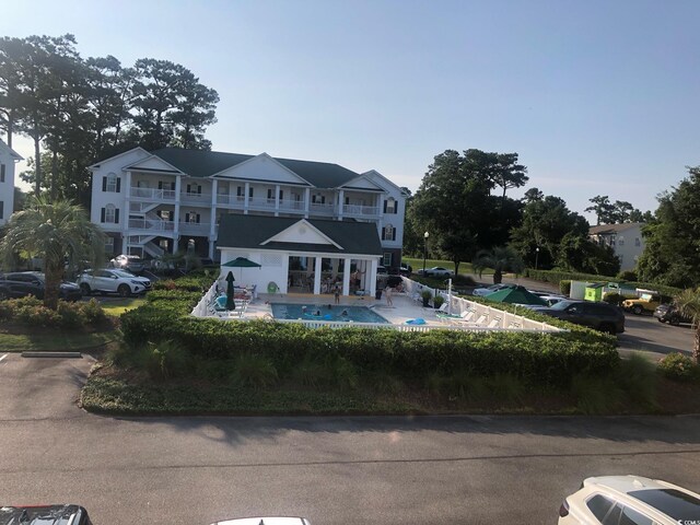 4400 Turtle Ln Unit 2-D, Little River, SC 29566 - rear view of property featuring an outdoor pool, a balcony, a patio, and uncovered parking