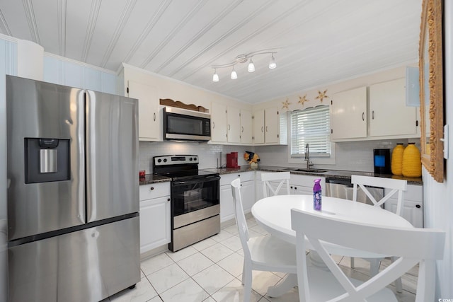 302 46th Ave N, North Myrtle Beach, SC 29582 - kitchen featuring stainless steel appliances, decorative backsplash, crown molding, white cabinetry, and light tile patterned floors