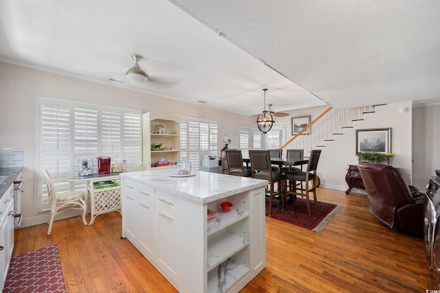 302 46th Ave N, North Myrtle Beach, SC 29582 - kitchen with open shelves, white cabinetry, ceiling fan, and a center island
