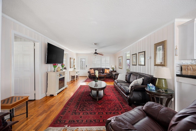 302 46th Ave N, North Myrtle Beach, SC 29582 - living area with crown molding, light wood-style flooring, ceiling fan, a textured ceiling, and a fireplace
