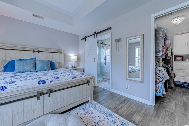 2479 Burning Tree Ln, Little River, SC 29566 - bedroom featuring wood finished floors, a barn door, a walk in closet, and ensuite bathroom