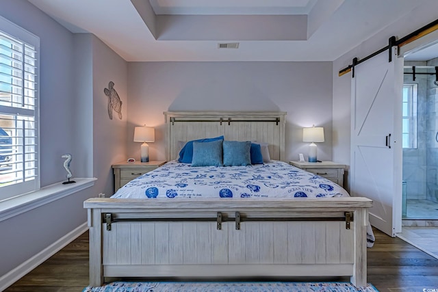 2479 Burning Tree Ln, Little River, SC 29566 - bedroom with a barn door, dark wood finished floors, and a raised ceiling