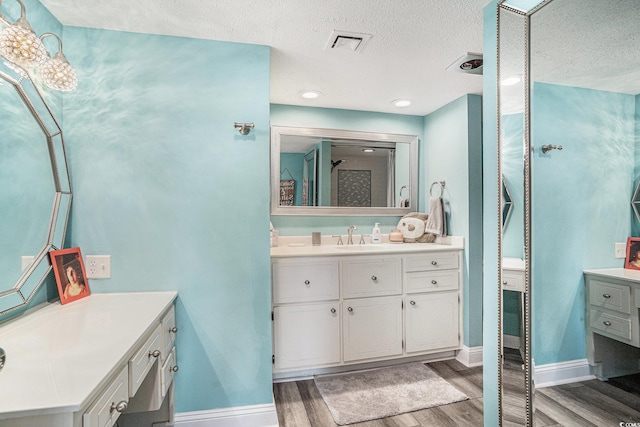 9650 Shore Dr Unit 209, Myrtle Beach, SC 29572 - full bathroom with wood finished floors, two vanities, and a textured ceiling