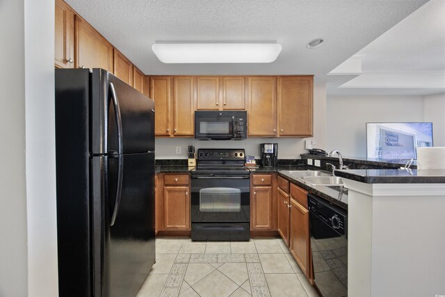 2600 N Ocean Blvd Unit 1914, Myrtle Beach, SC 29577 - kitchen with black appliances, light tile patterned flooring, inlaid floor details, dark countertops, and a peninsula