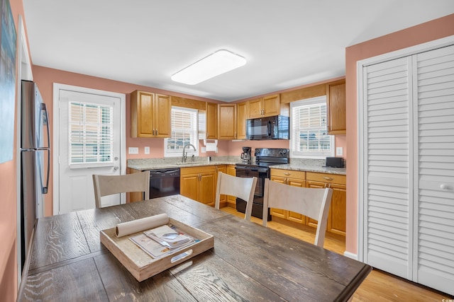 329 54th Ave N, North Myrtle Beach, SC 29582 - kitchen with black appliances, light wood-style flooring, and light stone counters