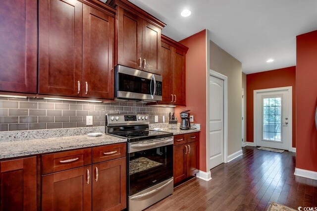 1733 24th Ave N, North Myrtle Beach, SC 29582 - kitchen with appliances with stainless steel finishes, dark wood finished floors, tasteful backsplash, light stone counters, and recessed lighting
